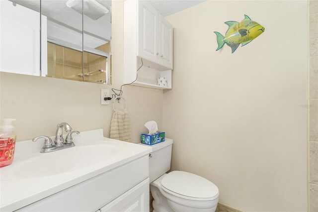 bathroom featuring toilet, a textured ceiling, and vanity