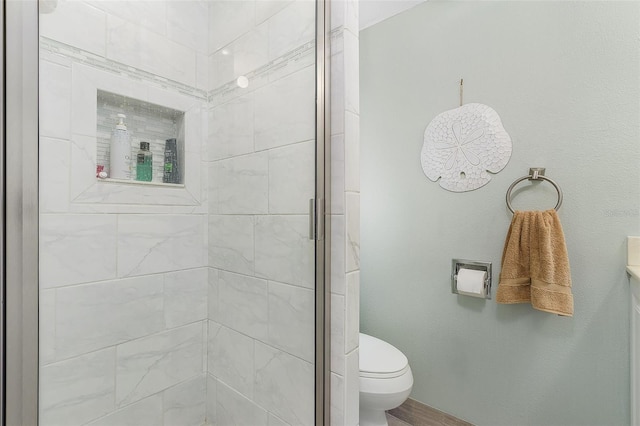 bathroom featuring toilet and a shower with door