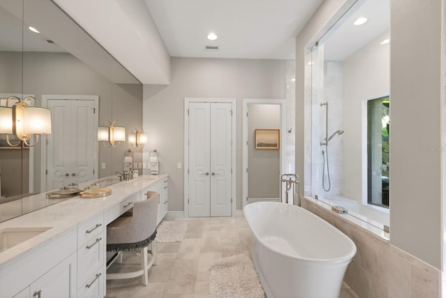 bathroom featuring vanity and independent shower and bath