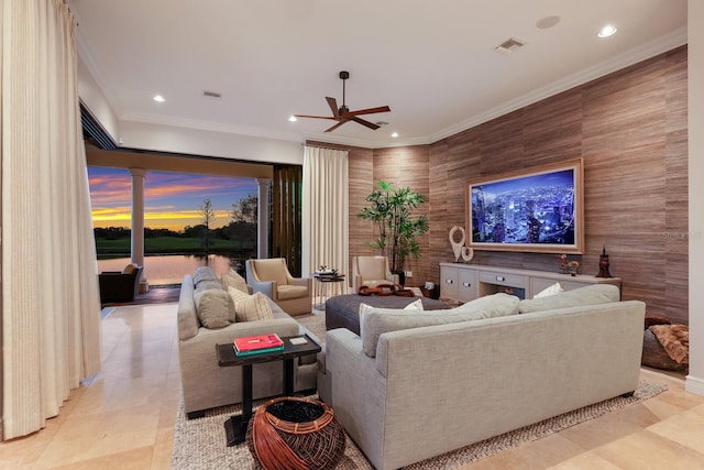 living room with light tile patterned flooring, ceiling fan, ornamental molding, and ornate columns