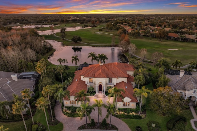 aerial view at dusk featuring a water view