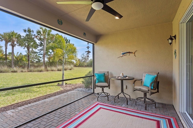 sunroom / solarium featuring ceiling fan