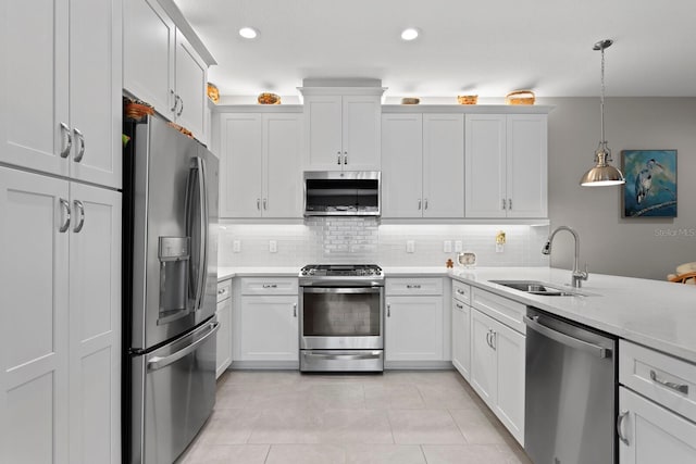 kitchen featuring white cabinetry, sink, stainless steel appliances, and decorative light fixtures