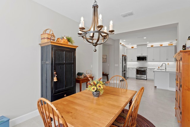 dining room featuring sink, light tile patterned floors, and a chandelier