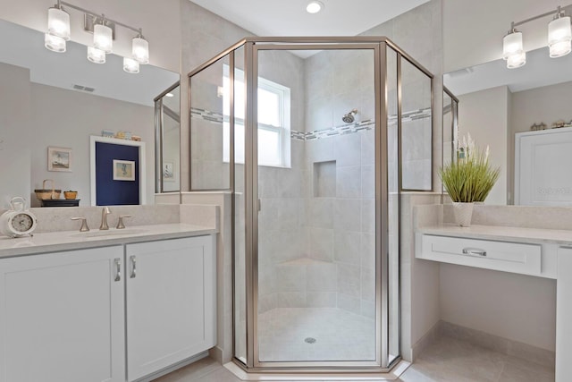 bathroom featuring tile patterned flooring, vanity, and a shower with door