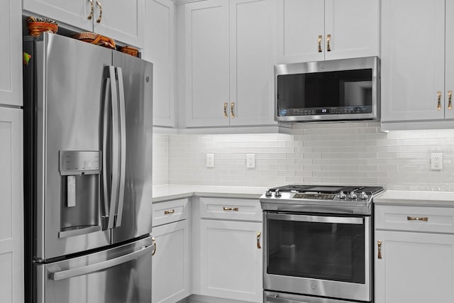 kitchen with white cabinets, stainless steel appliances, and tasteful backsplash