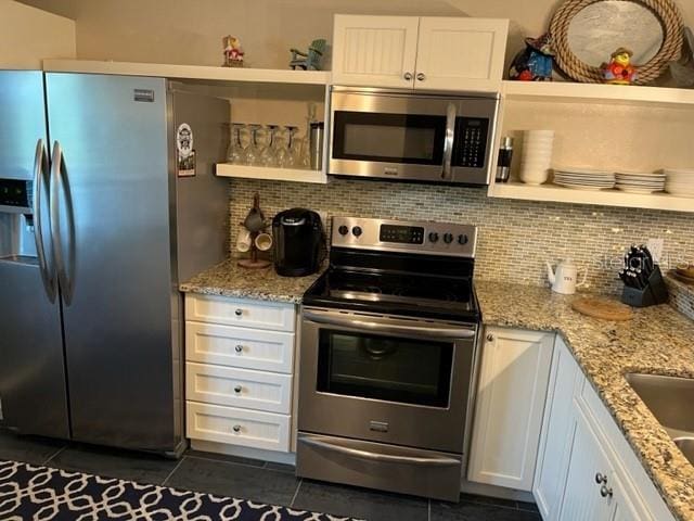 kitchen featuring backsplash, stainless steel appliances, and white cabinets