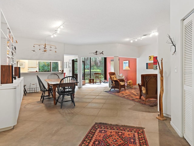 dining area with light tile flooring, a textured ceiling, and rail lighting