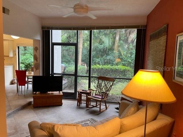 tiled living room with ceiling fan