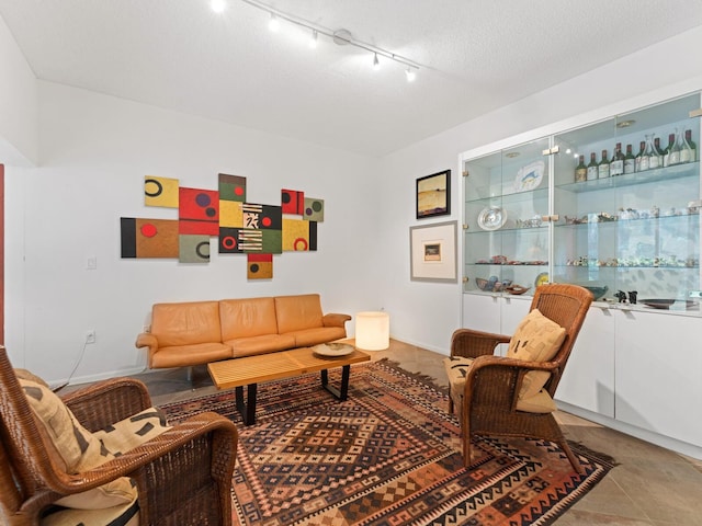 tiled living room with rail lighting and a textured ceiling