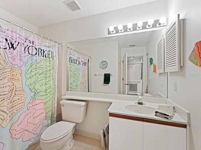 bathroom with vanity, a textured ceiling, tile flooring, and toilet