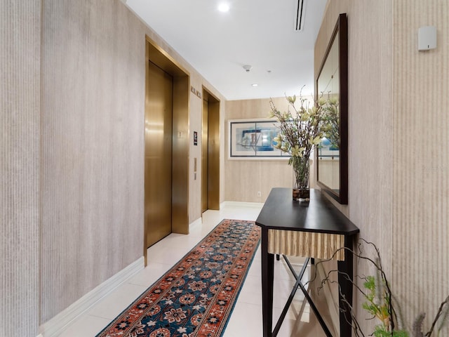 hall featuring elevator and light tile patterned floors