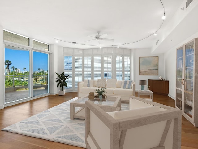 sunroom / solarium featuring ceiling fan and rail lighting