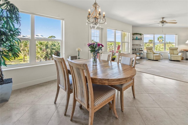 dining area featuring ceiling fan with notable chandelier, light tile floors, and a wealth of natural light