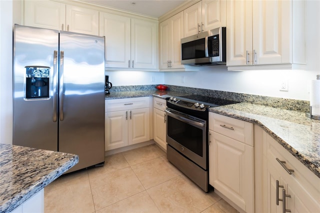 kitchen featuring light stone countertops, appliances with stainless steel finishes, and light tile floors