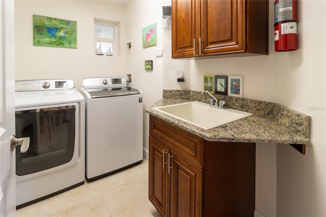 laundry area featuring light tile flooring, separate washer and dryer, cabinets, and sink