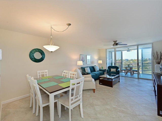 tiled dining space featuring expansive windows and ceiling fan