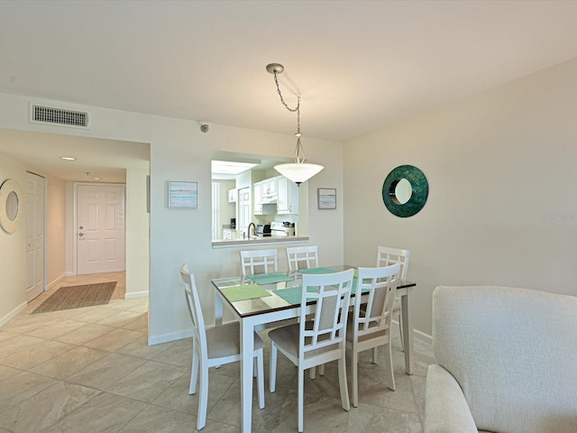 dining space featuring light tile floors and sink