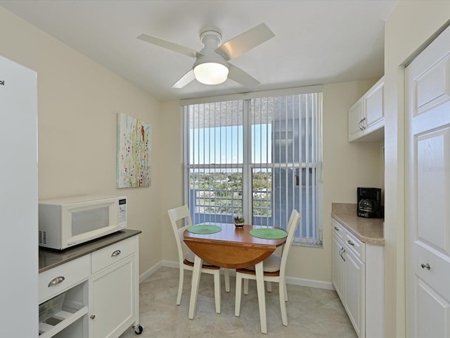 tiled dining area with ceiling fan