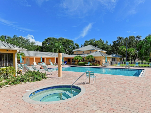 view of swimming pool featuring a hot tub and a patio area