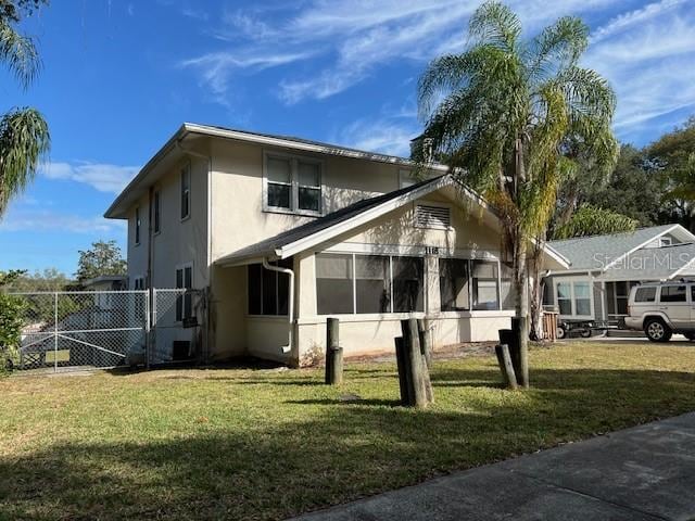 exterior space featuring stucco siding, a front yard, and fence