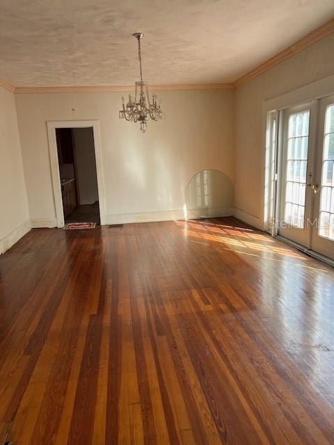 empty room with dark wood-style floors, baseboards, and ornamental molding