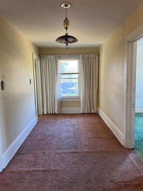 carpeted spare room with baseboards