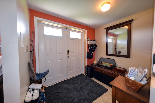 foyer entrance featuring dark carpet