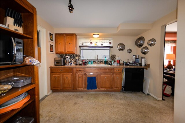 kitchen featuring tasteful backsplash, light colored carpet, sink, and black appliances