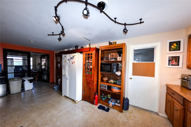 kitchen with white fridge with ice dispenser and rail lighting