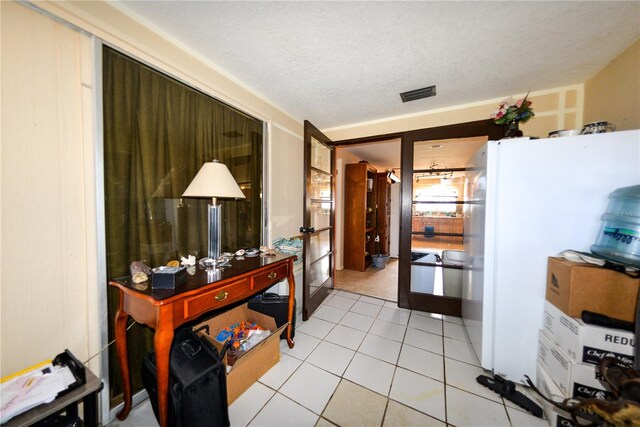 kitchen featuring light tile flooring, a textured ceiling, white fridge, and french doors