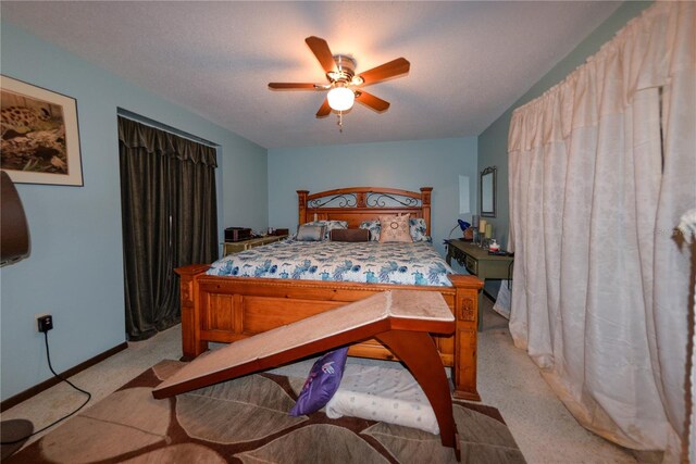 carpeted bedroom featuring ceiling fan and a textured ceiling