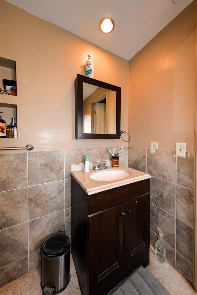 bathroom featuring vanity, tasteful backsplash, and tile walls