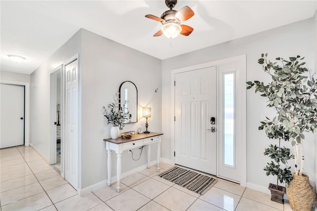 entrance foyer with a healthy amount of sunlight, ceiling fan, and light tile floors