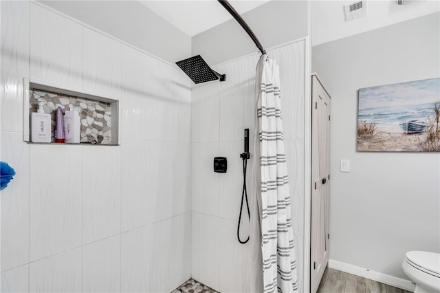 bathroom with curtained shower, hardwood / wood-style floors, and toilet