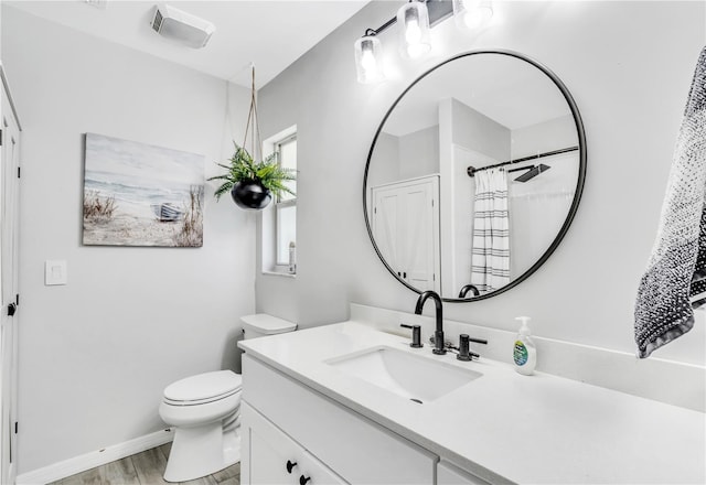 bathroom featuring toilet, vanity with extensive cabinet space, and hardwood / wood-style flooring