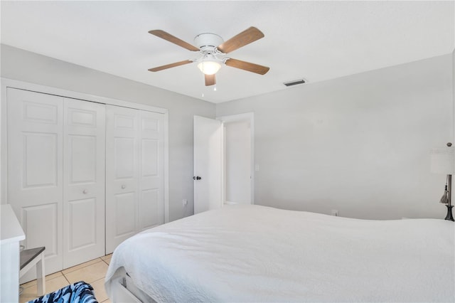 bedroom with light tile floors, a closet, and ceiling fan