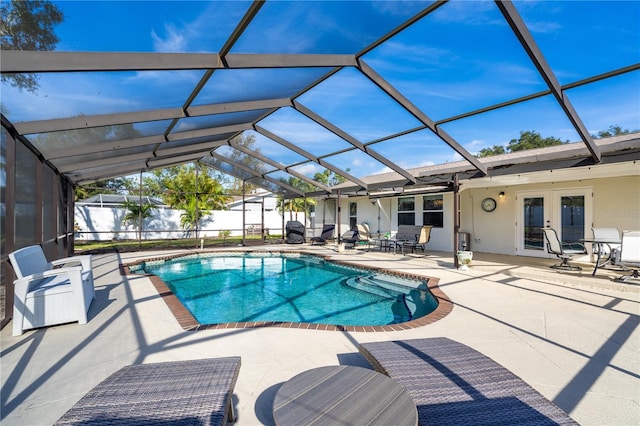 view of pool featuring a patio area, a lanai, and french doors