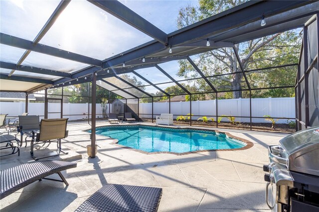 view of pool with area for grilling, a patio area, and glass enclosure