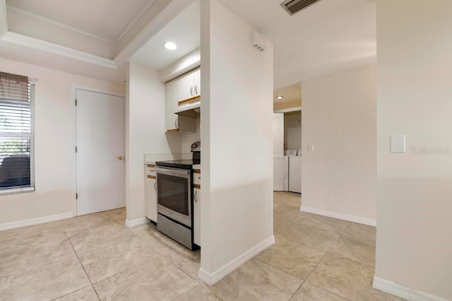 kitchen with range, white cabinetry, a tray ceiling, range hood, and light tile floors