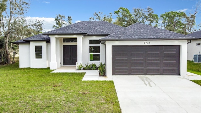 view of front of property with central AC, a front lawn, and a garage