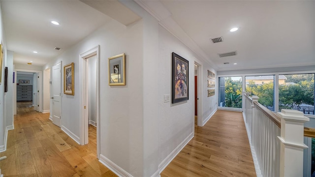 corridor with crown molding and light hardwood / wood-style flooring