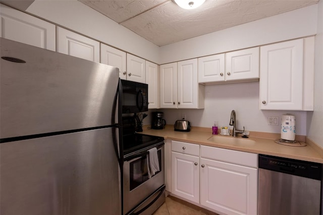 kitchen featuring light tile flooring, white cabinetry, appliances with stainless steel finishes, and sink