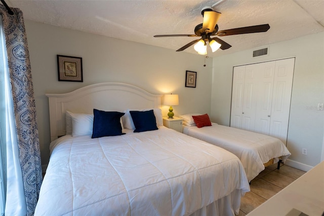 bedroom featuring a closet, a textured ceiling, and ceiling fan