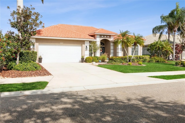 mediterranean / spanish-style house with a front yard and a garage