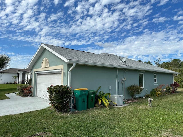 view of side of home featuring a lawn, central AC unit, and a garage