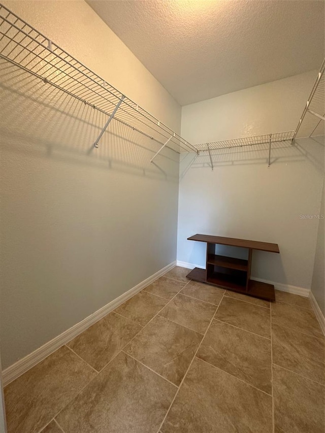 spacious closet featuring tile flooring