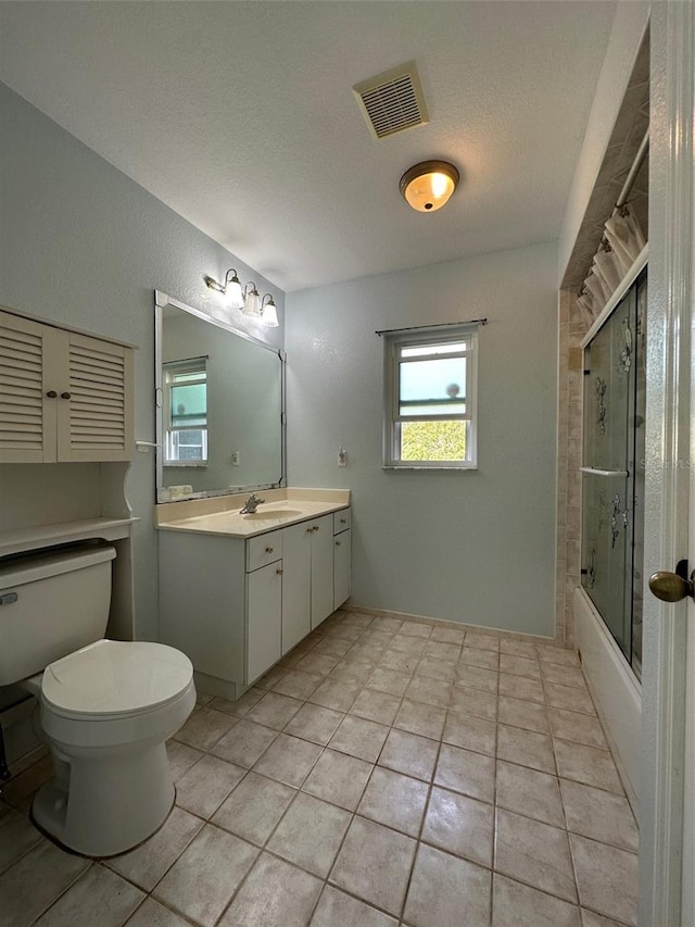 full bathroom featuring tile floors, toilet, vanity, and a textured ceiling