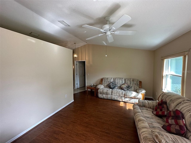 living room with lofted ceiling, ceiling fan, a textured ceiling, and dark hardwood / wood-style flooring