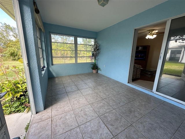 unfurnished sunroom with ceiling fan